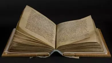 An open parchment manuscript, showing the new wooden boards and newly sewn blue and white endband.